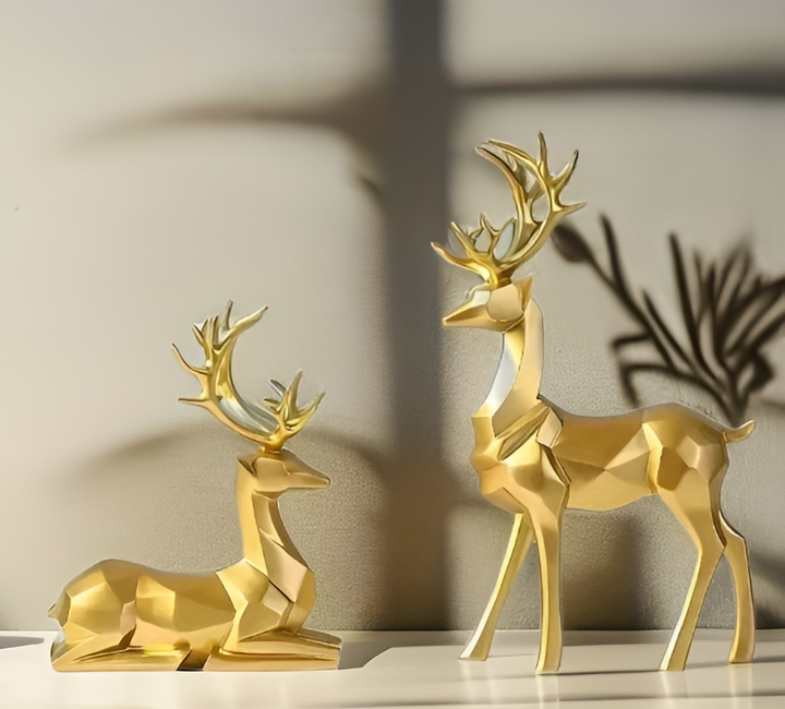 Elegant rensdyrsæt i harpiks til juledekoration, perfekt til bordet med guld og hvide figurer.