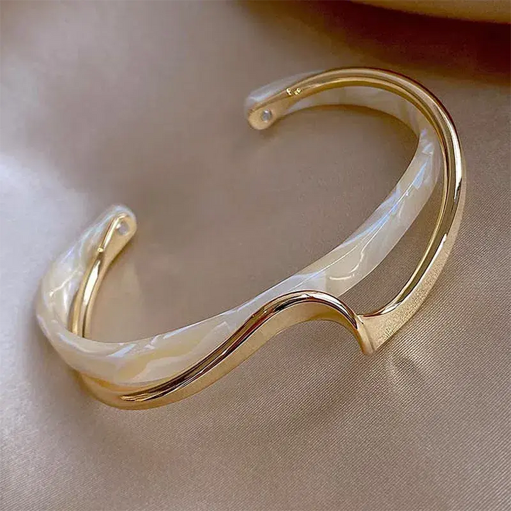 Elegant skulpturelt åbent manchetarmbånd til damer i moderne design, perfekt som stilfuldt statement smykke.