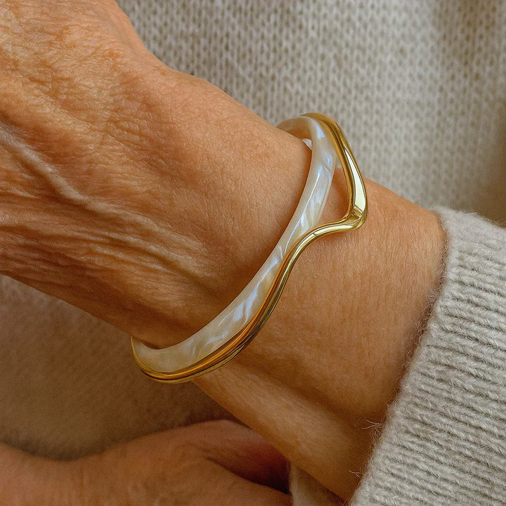 Moderne minimalistisk guld manchetarmbånd med åbent design til kvinder. Et elegant armbånd til håndleddet.