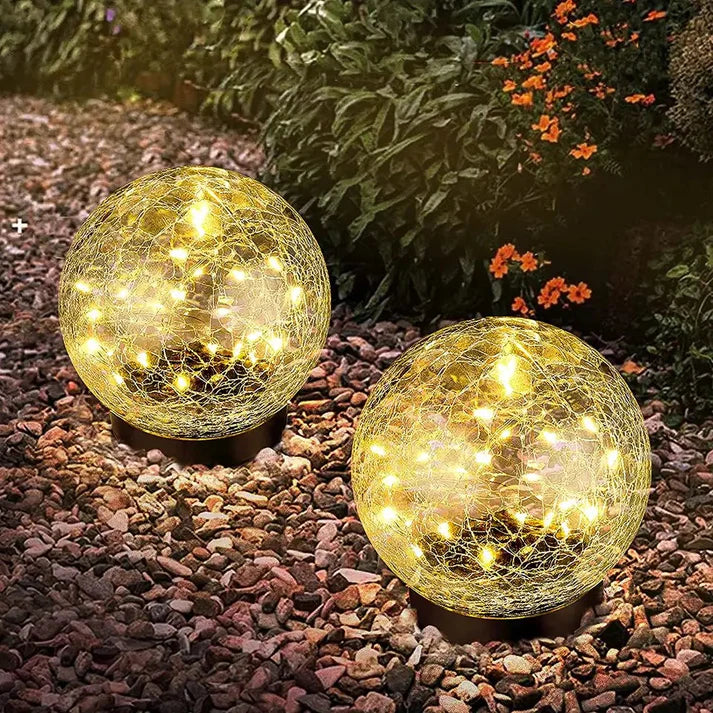 Nærbillede af den smukke krakelerede glaskugle på en solcellelampe, der giver unikt udendørs lys.
