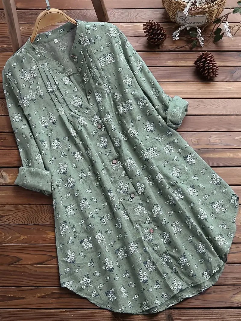 "Elegant sommerbluse i bomuld med blomstermønster, omvendt krave og løs pasform. Perfekt til feminint sommerlook."