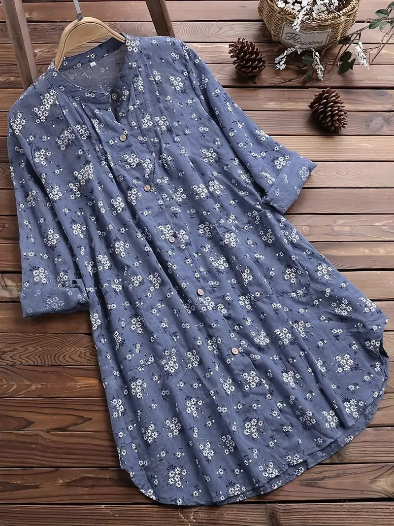 "Elegant sommerbluse i bomuld med blomstermønster, omvendt krave og løs pasform. Perfekt til feminint sommerlook."