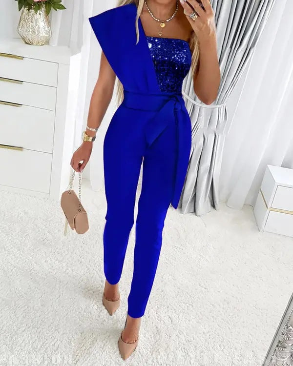 Stilfuld blå aftenjumpsuit med glitrende one shoulder. Festlig og moderne dame mode.