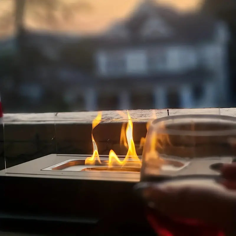"Elegant sort bioethanol udendørspejs i rustfrit stål, dimensioner 35x18x14 cm, skaber hygge og varme i haven."