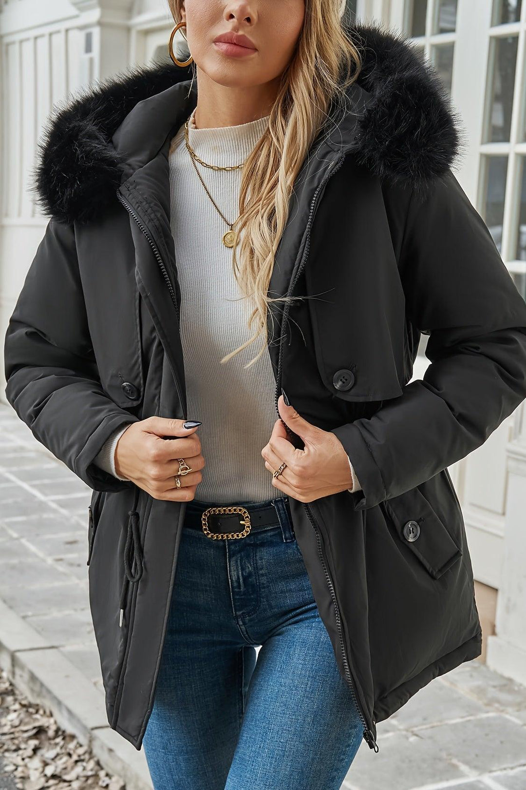 Detaljeret visning af den bløde faux fur på hætten af en elegant sort dame vinterjakke. Vintermode.