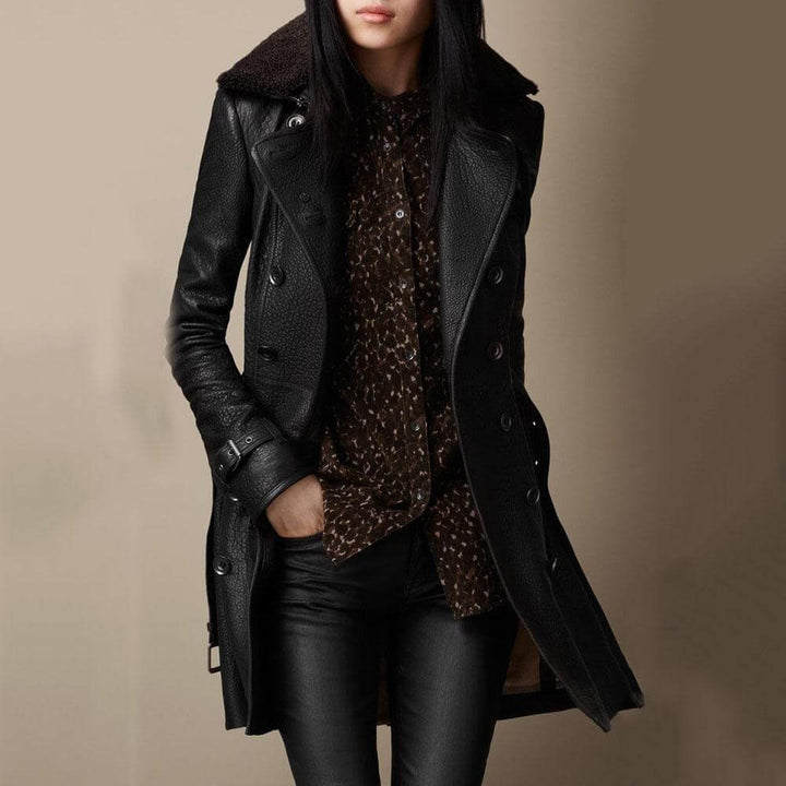 Lang læderlook trenchcoat til kvinder med bælte, der kombinerer elegant og rå stil.