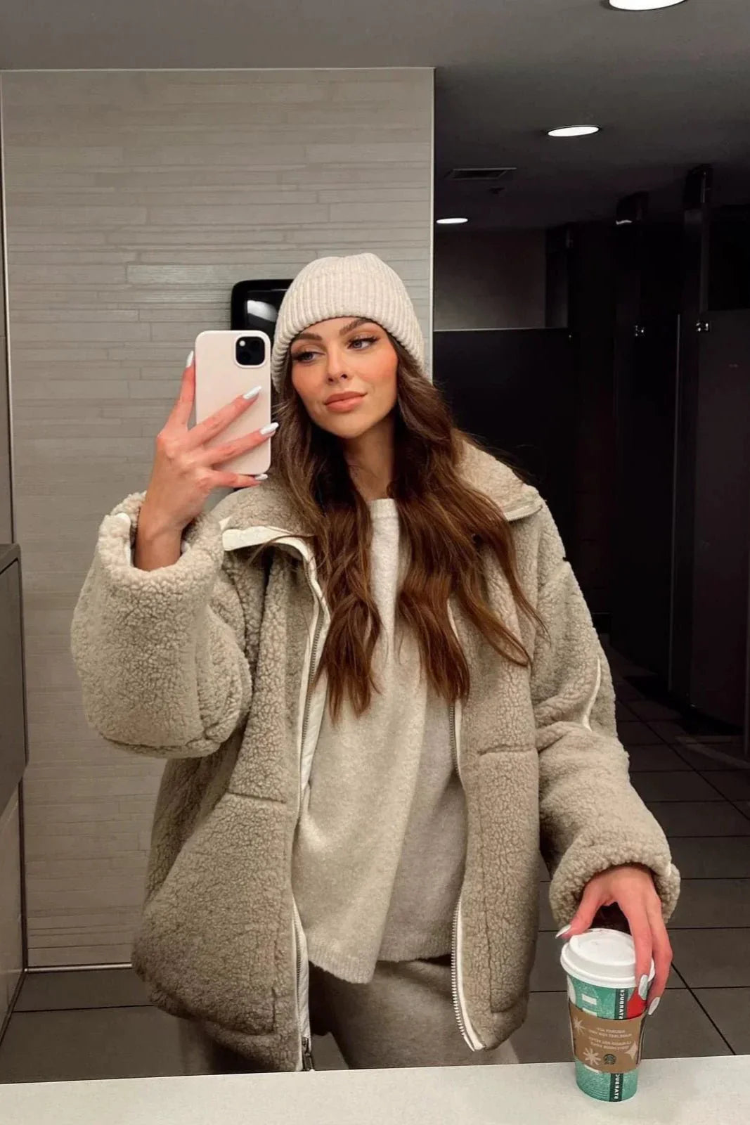 Nærbillede af blødt teddyfleece på elegant damekåbe, kvindemode i nordisk stil.