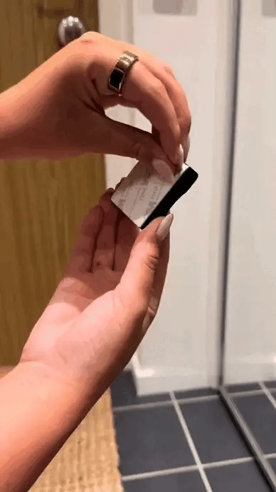 Billede af en person der bruger det væghængte magnetiske træ skohorn med lethed.