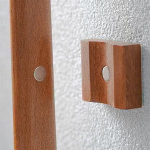 Minimalistisk væghængt skohorn i træ, magnetisk og pladsbesparende til ethvert hjem.