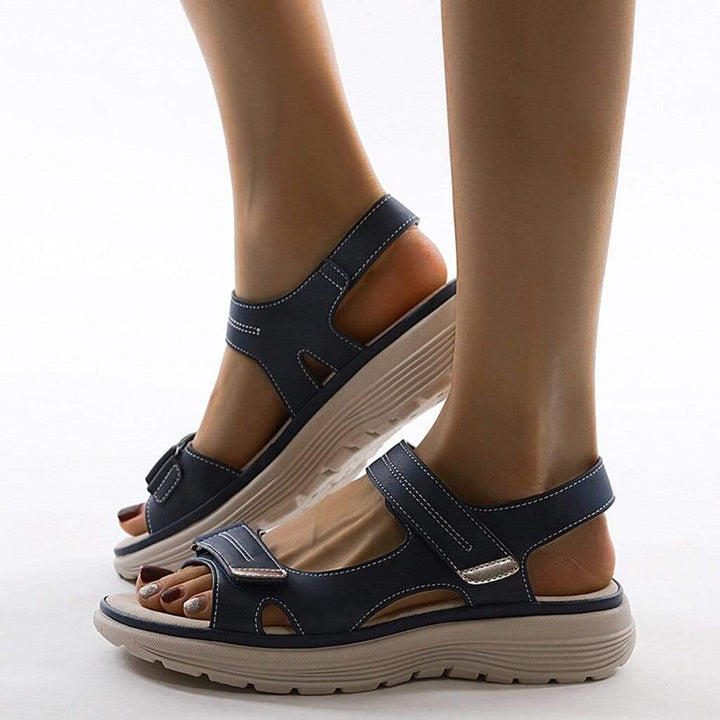 "Elegante damensandaler med blød sål og justerbare remme til støtte mod hælsmerter og bunions, i beige, blå og sort."