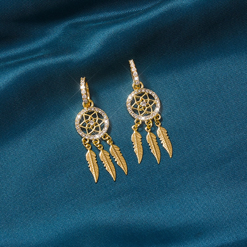 Detaljerede drømmefangerøreringe i 14K guld. Inkluderer fine fjer og delikat kvindesmykke design.