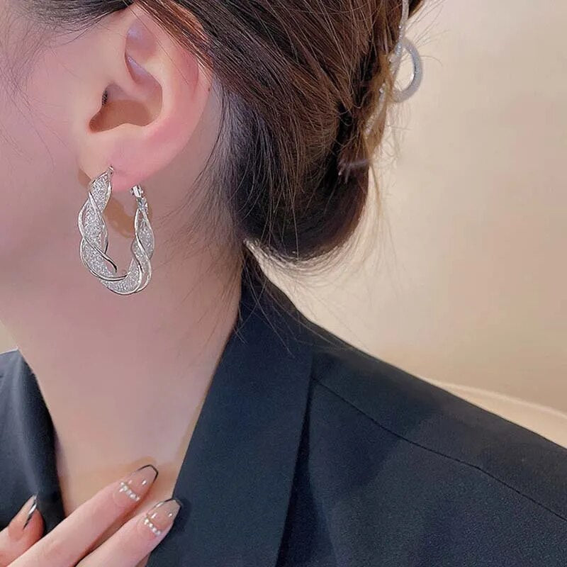 Guld creoløreringe med elegant snoet mønster. Perfekte guldsmykker for et raffineret look.