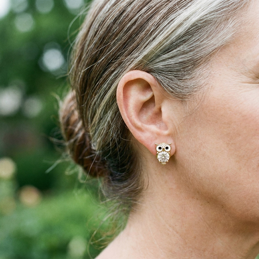 Kvinders ørestikker i guld formet som ugler med glitrende krystaller, et elegant smykke til hende.