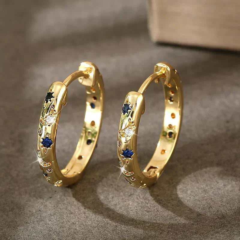 Elegante kvinders guld creoler med farvede sten. Tidløse hoop øreringe perfekte til fest eller hverdag.