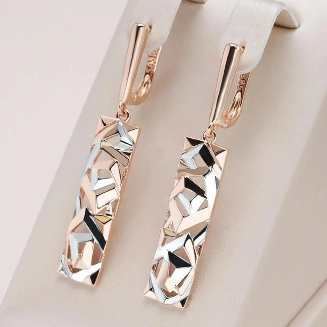 Elegante kvinders lange tofarvede geometriske øreringe i guld og sølv. Perfekte til et moderne statement-look.