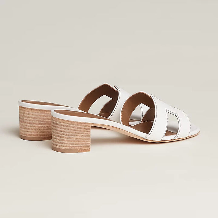 Hvide kvinders slip-on sandaler med åben tå. Elegant design og komfortabel mellemhøj blokhæl. Ideelle sommer sandaler.