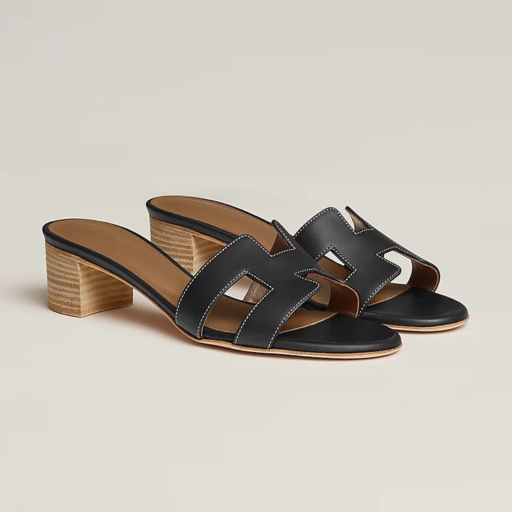 Nærbillede: Elegante kvinders slip-on sandaler med åben tå, komfortabel blokhæl og luksuriøse detaljer.