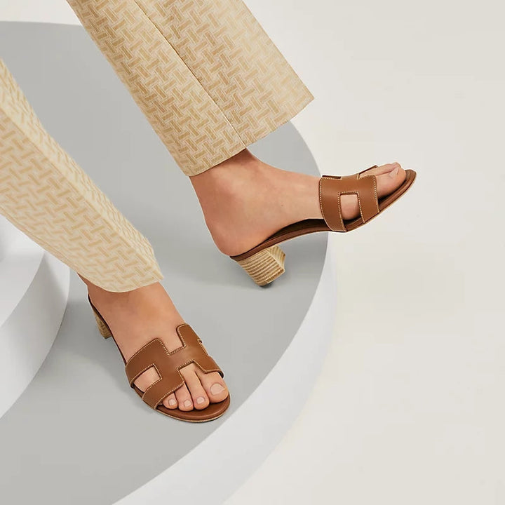 Gruppe af stilfulde kvinders slip-on sandaler i brun, sort og hvid. Åben tå, komfortabel blokhæl til sommer.