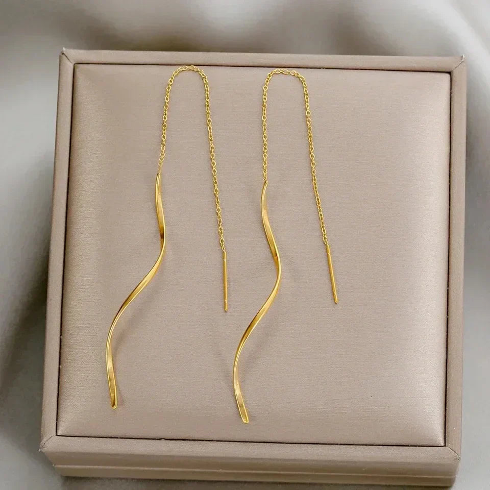 Iøjnefaldende lange bølgede øreringe til kvinder. Et elegant statement-smykke i guld.