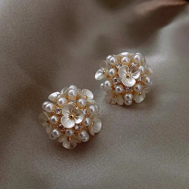 Elegante perleøreringe i blomsterdesign til kvinder. Klassiske ørestikker perfekte som bryllupssmykker eller festøreringe.