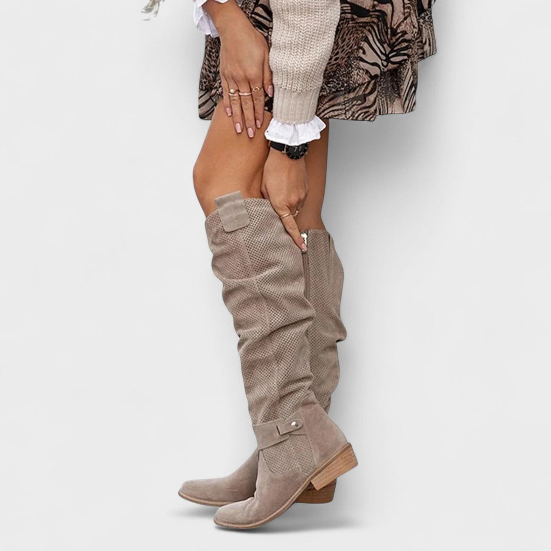 Nærbillede af elegante sorte knæhøje støvler til kvinder, der fremhæver det klassiske fashion design.