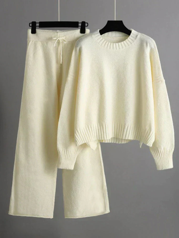 Nærbillede af det bløde, strikkede stof fra damesættet, der viser teksturen af sweater og brede bukser.