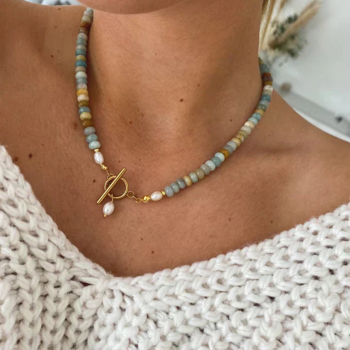 Farverig dame perlehalskæde med skinnende perler, smukke natursten og en elegant guldlås. Perfekt sommerlook.