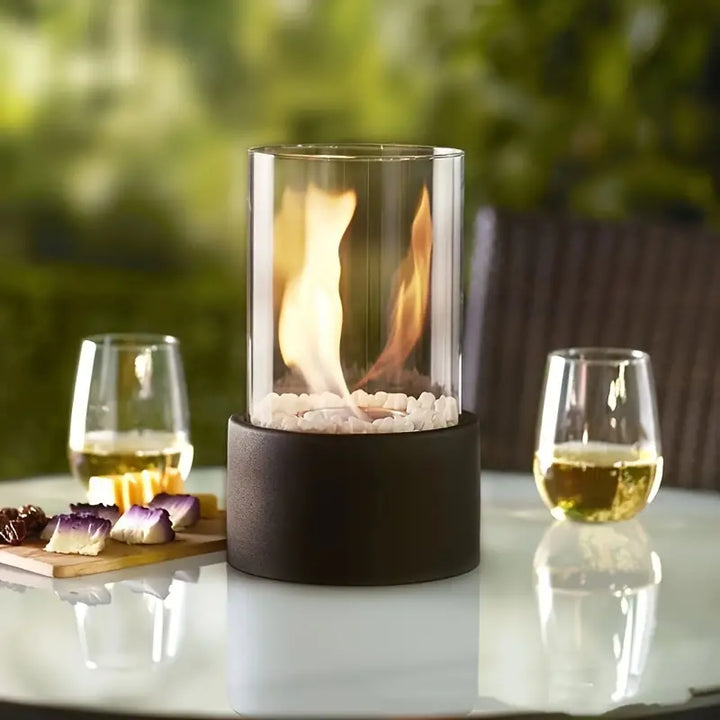 FlameAura bordpejs i et lyst interiør. Tilfører kontrast, hygge og en levende flamme.