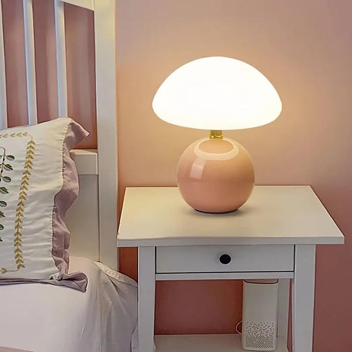 "Flødefarvet svampeinspireret bordlampe med Bauhaus-æstetik, cremefarvet skærm og elegant keramisk base."
