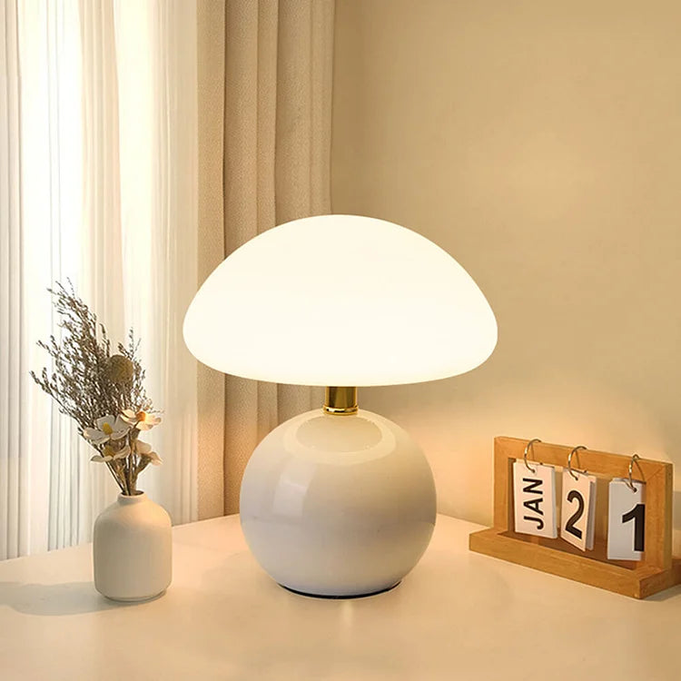 "Flødefarvet svampeinspireret bordlampe med Bauhaus-æstetik, cremefarvet skærm og elegant keramisk base."