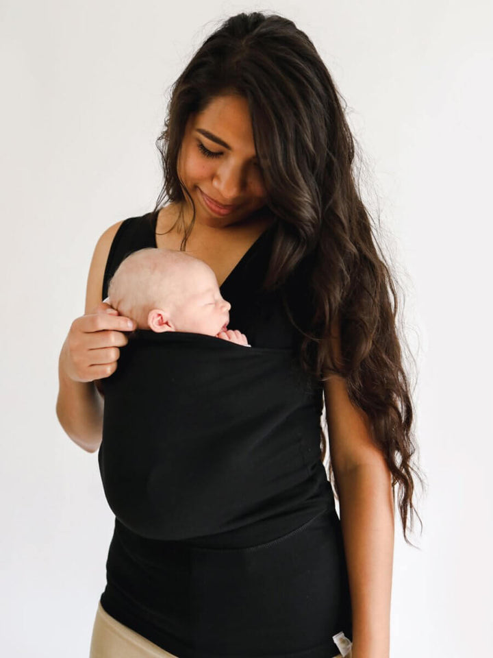 Forælder bærer baby i ergonomisk bære-t-shirt. Oplev hverdagskomfort og nærhed med din lille.