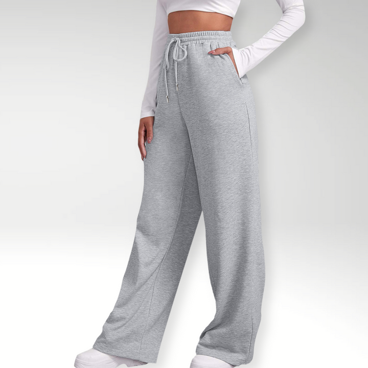 Grå dame sweatpants med høj talje og brede ben. Komfortable og stilfulde athleisure bukser til moderne fritid.