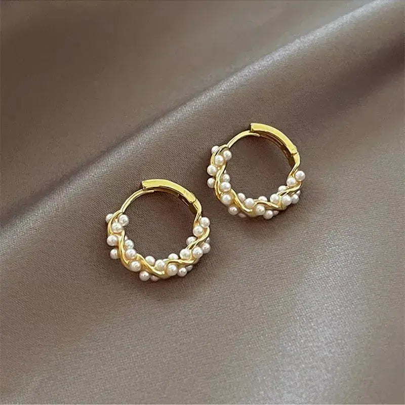 Guldfarvede creoler med elegante perler og unikt twist design til kvinder.