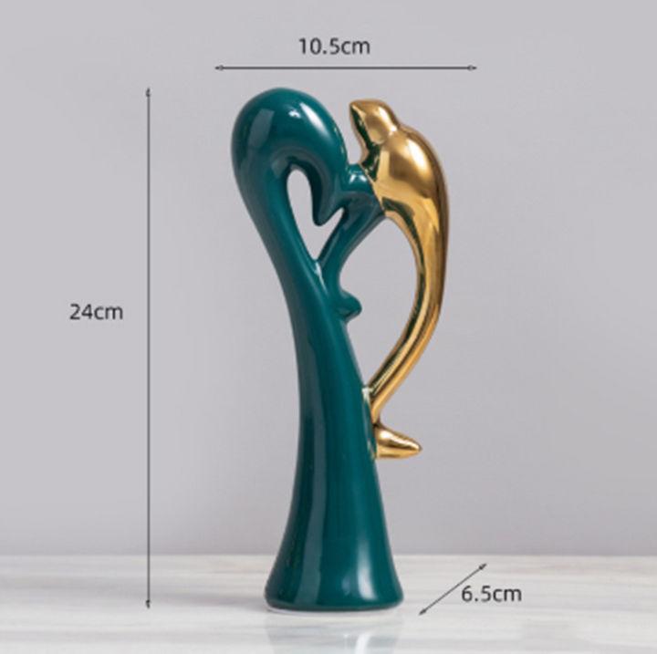 Nærbillede af smaragdgrønne og gyldne Love Birds figurer, detaljeret håndværk og moderne design.