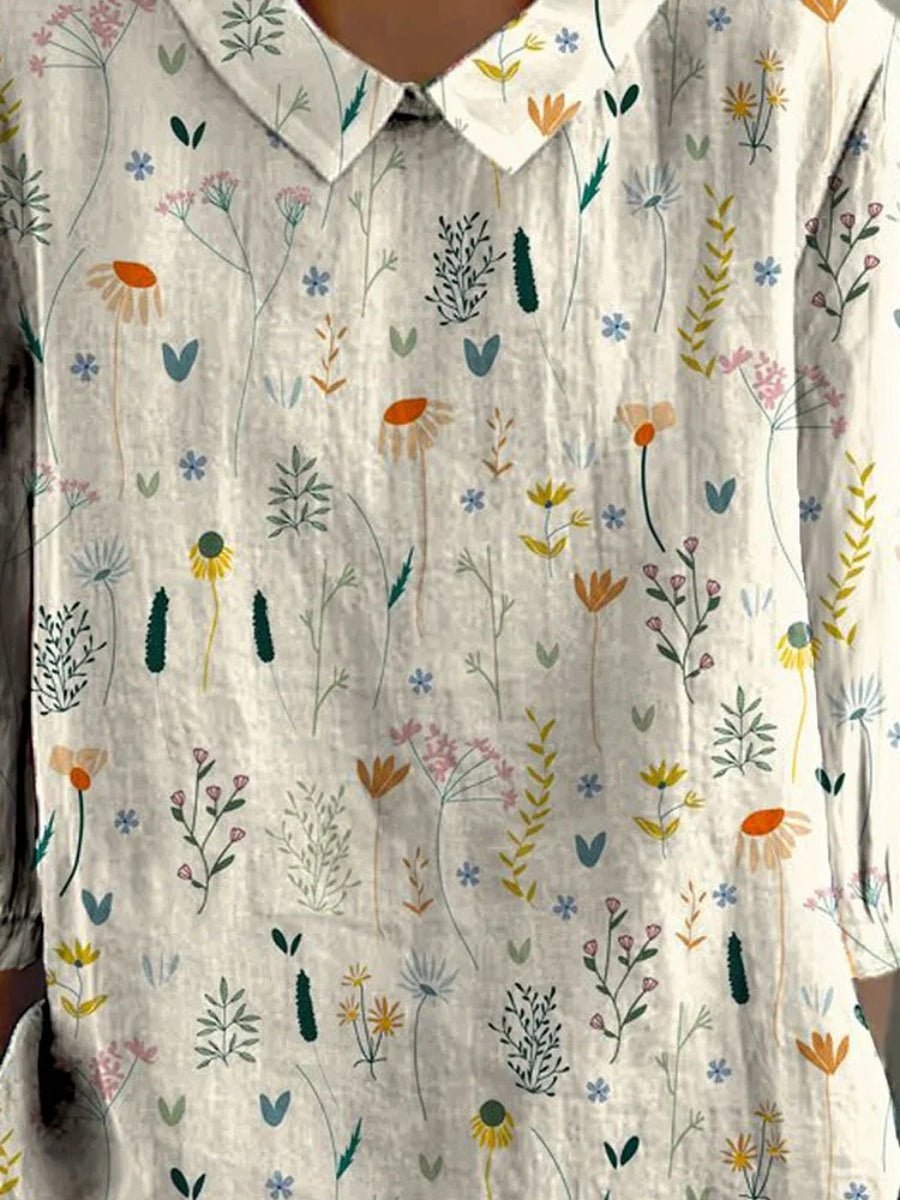 Feminin hvid polo bluse til kvinder med klassisk krave og moderne blomsterprint. Ideel til afslappet hverdagsmode.