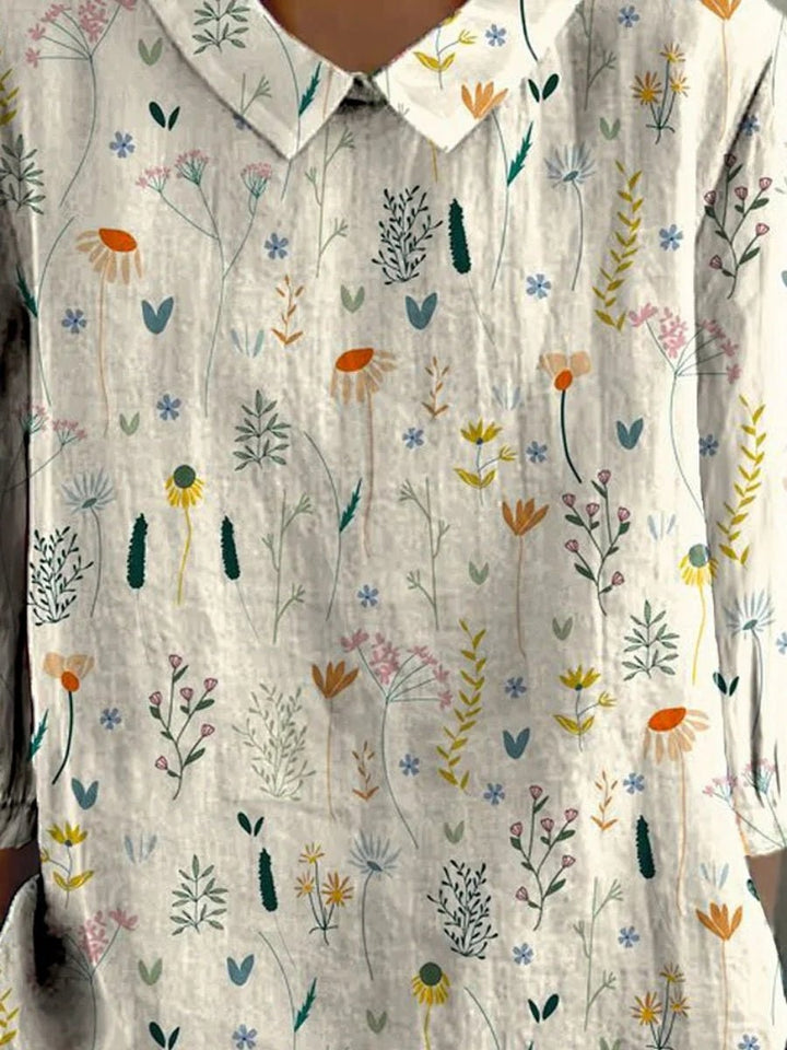 Feminin hvid polo bluse til kvinder med klassisk krave og moderne blomsterprint. Ideel til afslappet hverdagsmode.