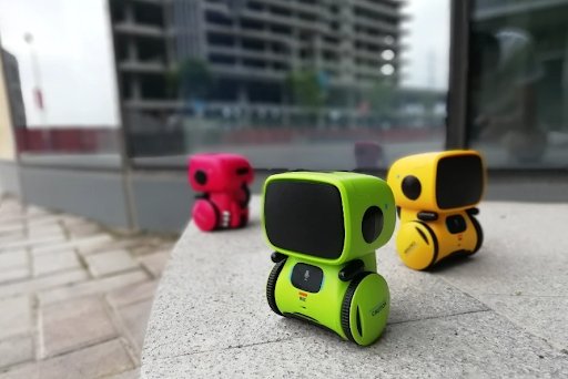 "Interaktiv dansende robot til børn, hvid og blå, synger og reagerer på stemmer, fremmer læring og leg, børnesikker."