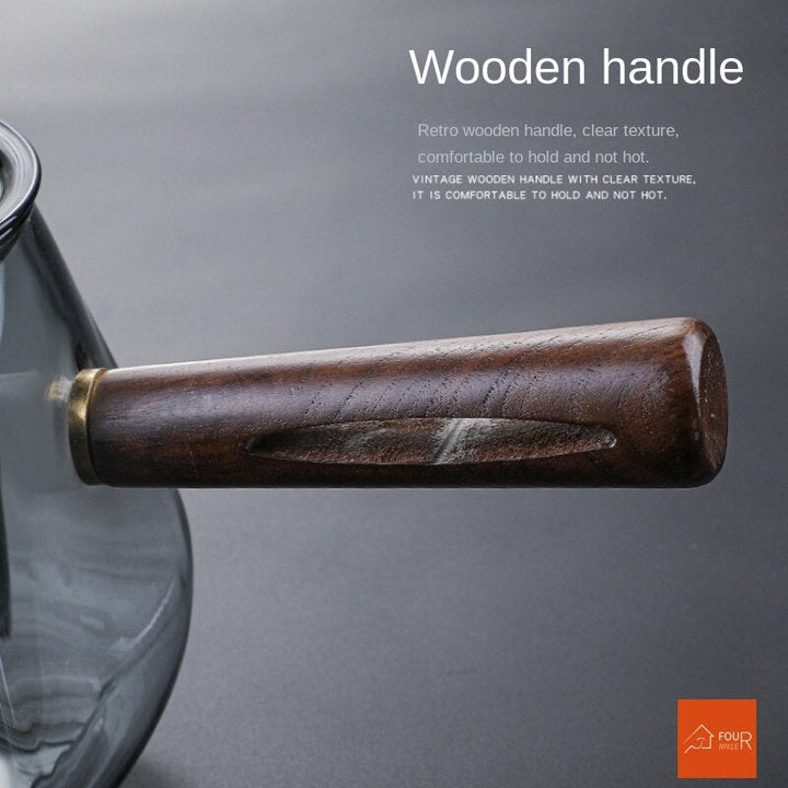 Elegant tekande af glas med træhåndtag, perfekt til teceremoni og servering af løs te.