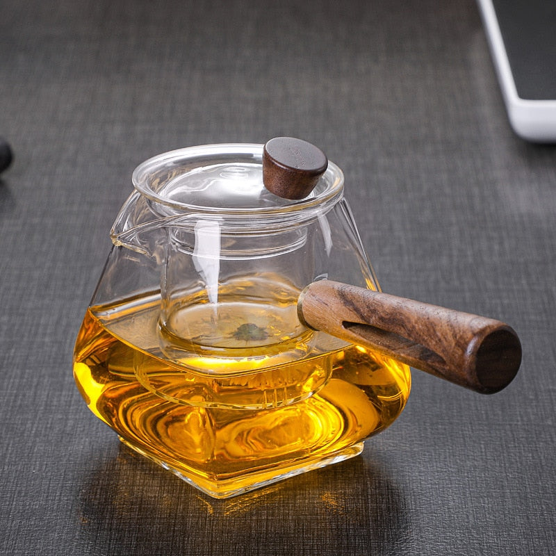 Håndlavet udseende glas tekande med træhåndtag, til brygning og servering af løs te i hjemmet.