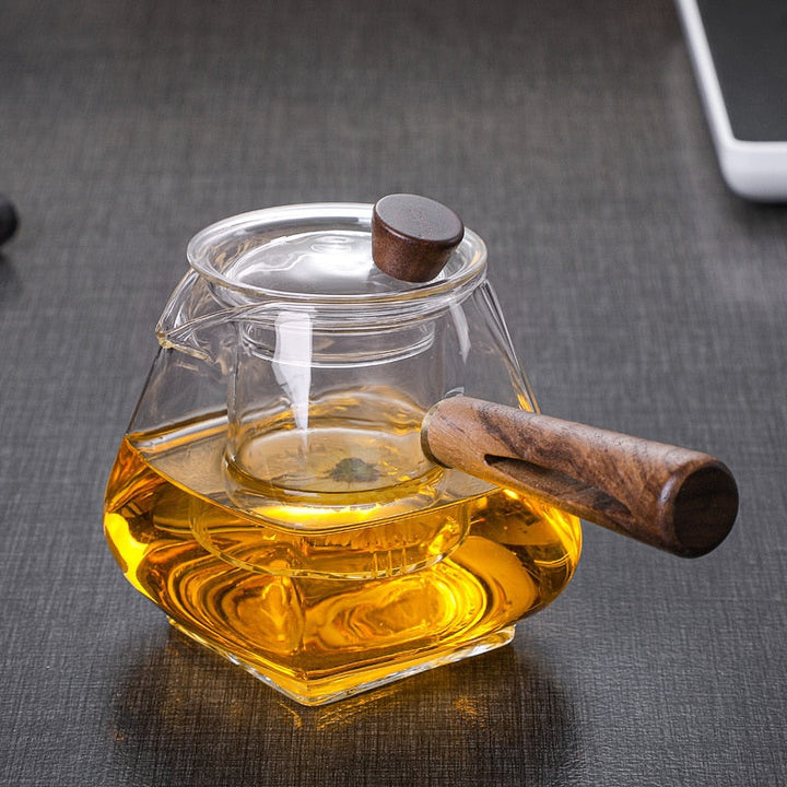 Håndlavet udseende glas tekande med træhåndtag, til brygning og servering af løs te i hjemmet.