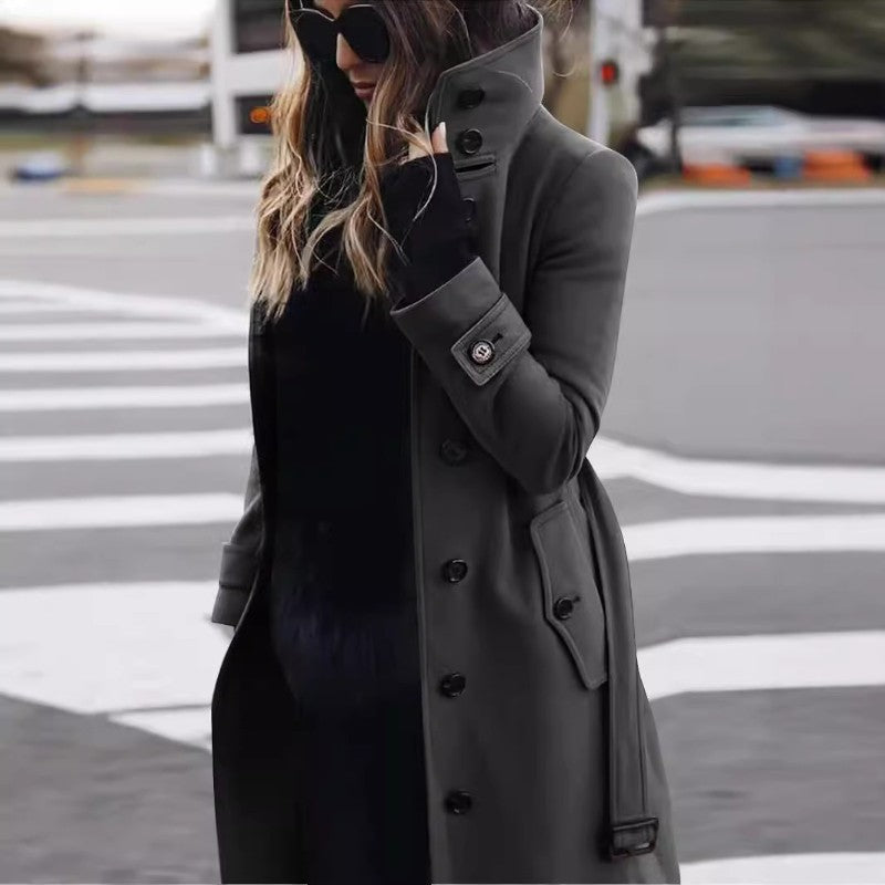 Detaljeret billede af dame trenchcoat med knapper, bælte og store lommer. Moderne klassisk design.