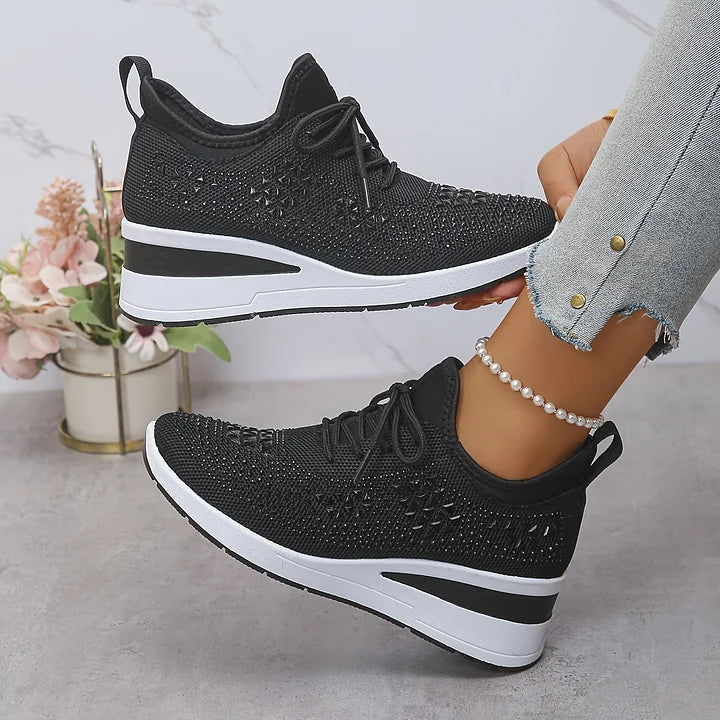 Nærbillede af kvinders sneakers med glitrende rhinsten, der tilføjer glamour til ortopædisk fodtøj.
