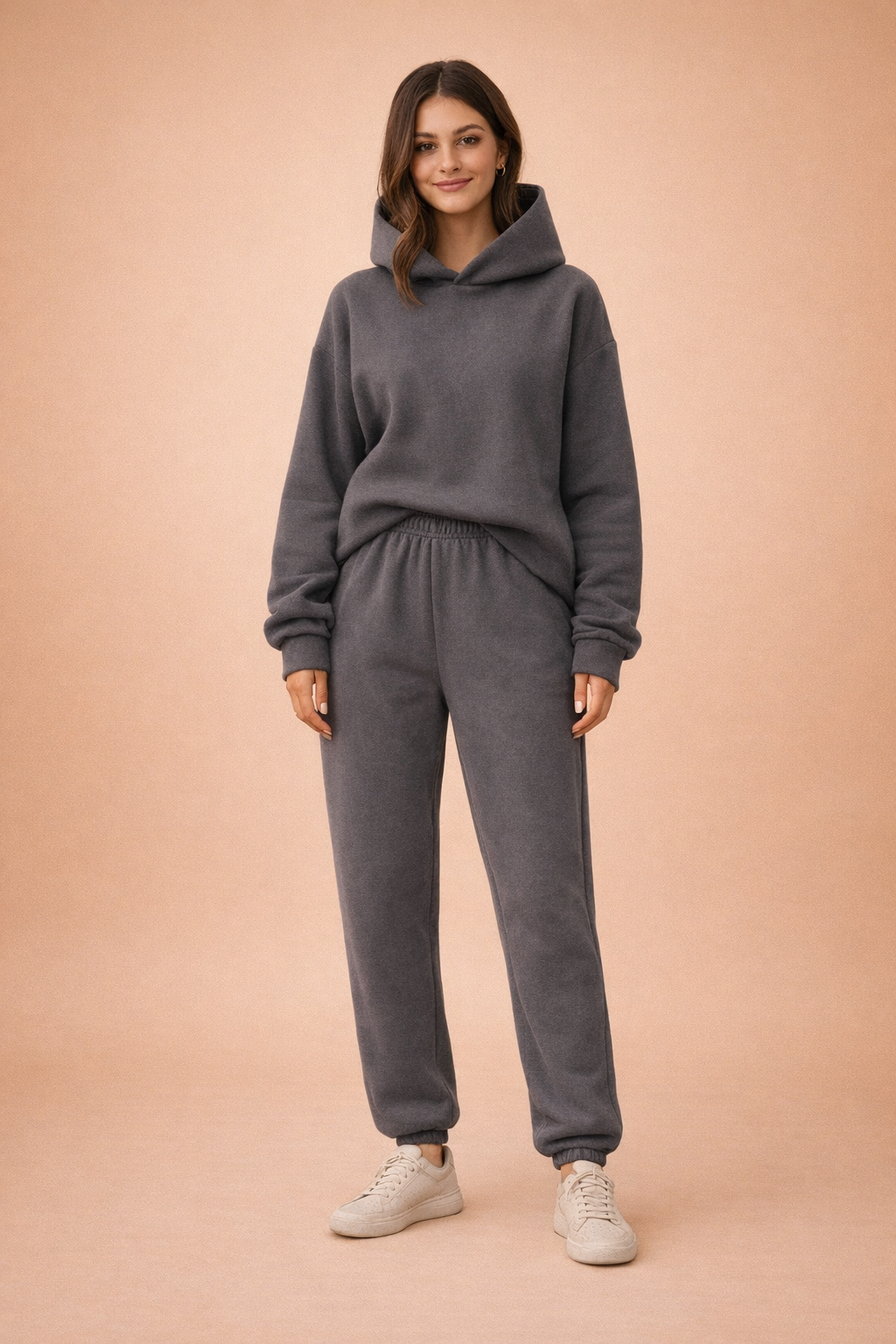 Komfortabel kvinders oversized hættetrøje og matchende sweatpants, del af et moderne fritidssæt.