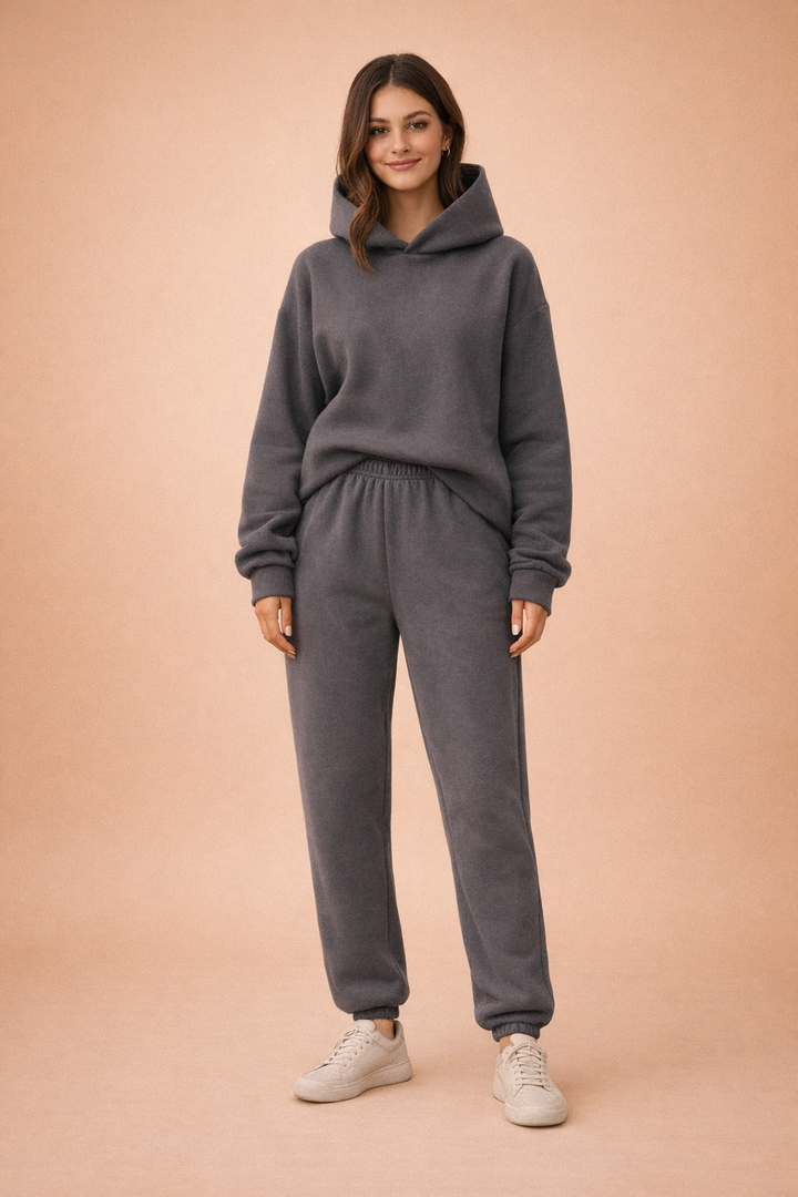 Komfortabel kvinders oversized hættetrøje og matchende sweatpants, del af et moderne fritidssæt.