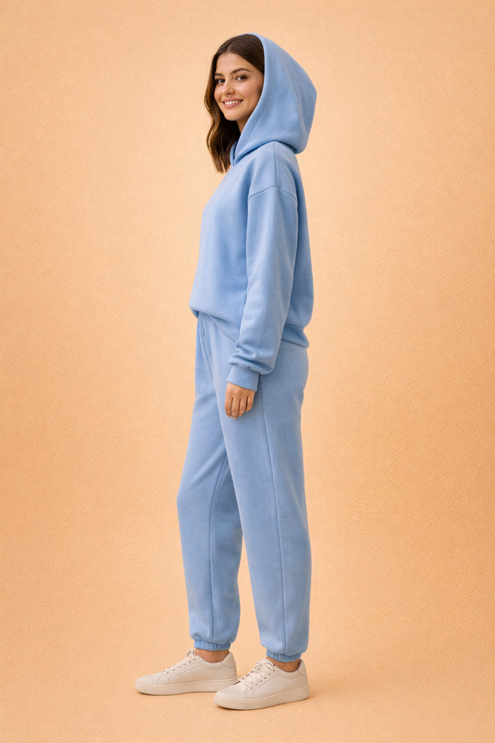 Model viser oversized hættetrøje og joggingsæt til kvinder i urban stil, perfekt til fritid og afslapning.