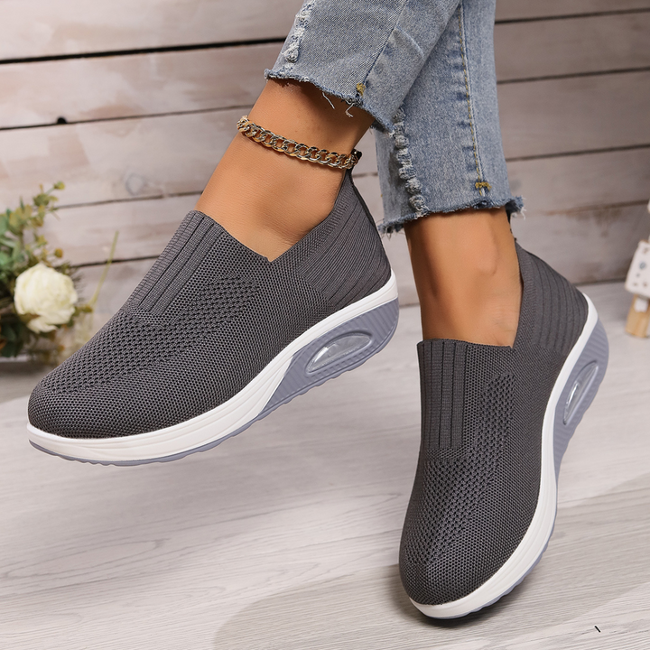 Kvinde iført moderne slip-on sneakers. Komfortable og nemme hverdagssko, perfekte til fritid og sommer.