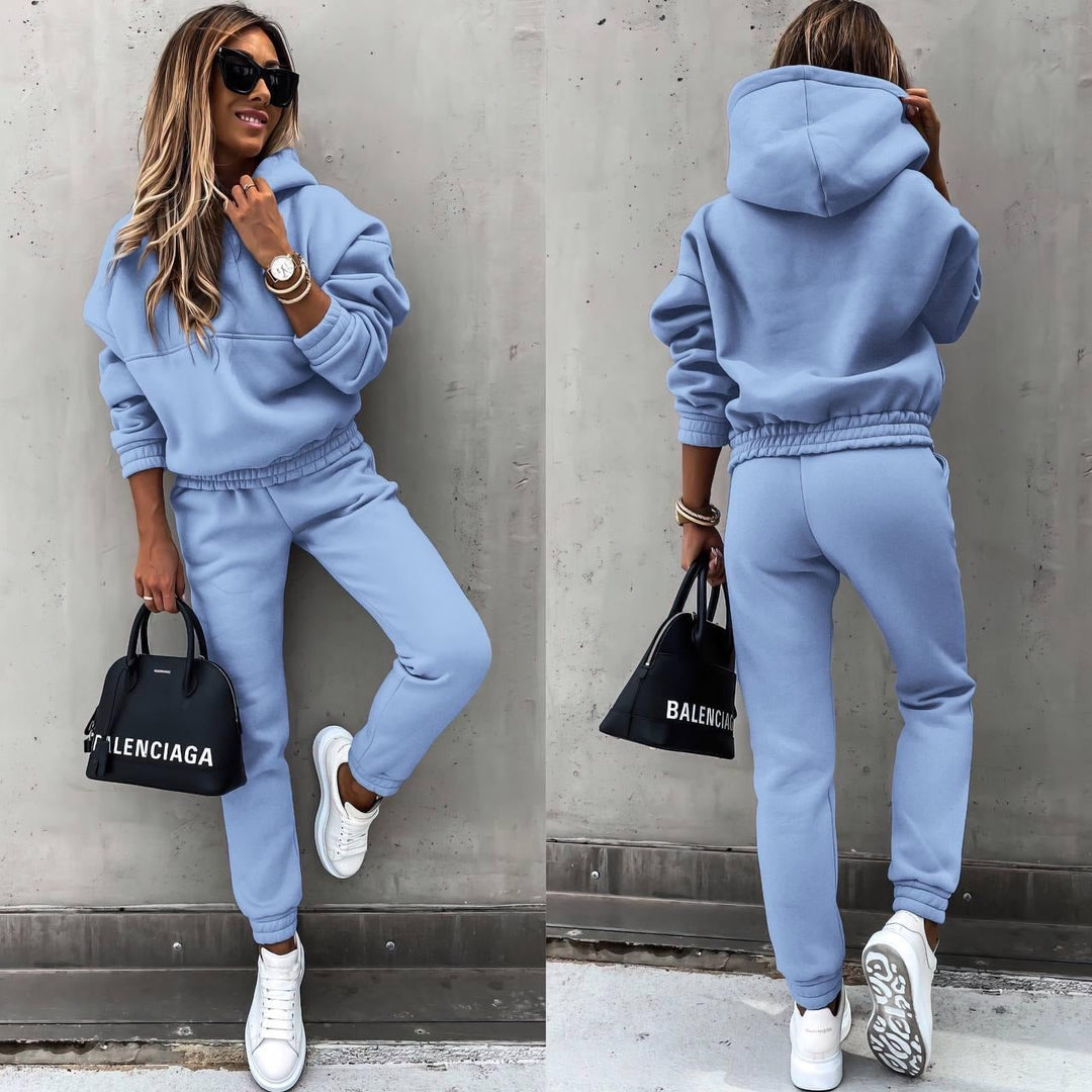 Model iført kvinders sporty todelt sæt med sweatshirt og matchende joggingbukser i blødt stof.
