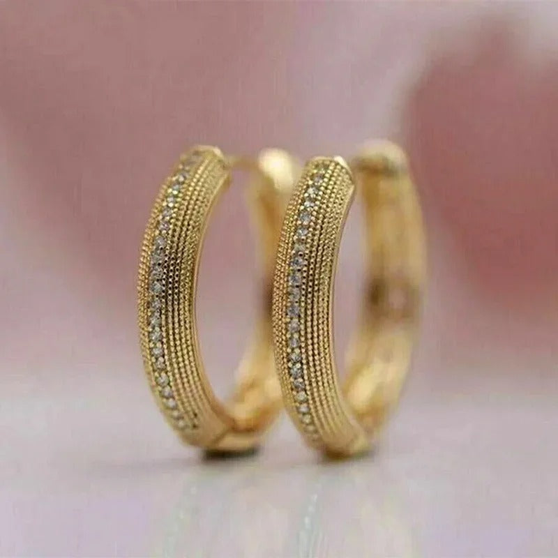Kvinders brede guld creoler med eksklusiv struktureret overflade. Elegante dameøreringe, perfekte til fest & hverdag.