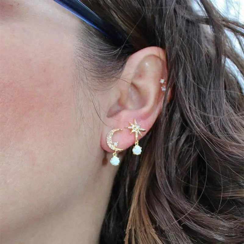 Romantiske dingle øreringe til kvinder med måne, stjerne og opal. Elegante himmelske smykker i guld.