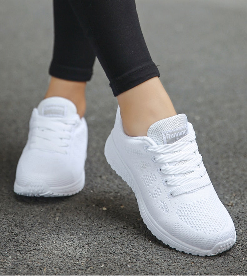 Kvinde iført letvægts sneakers; viser stil og komfort i hverdagen. Moderne og sporty chic.
